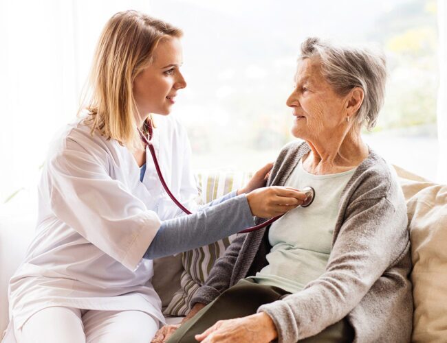 doctor taking a senior woman's heart rate with a stethoscope