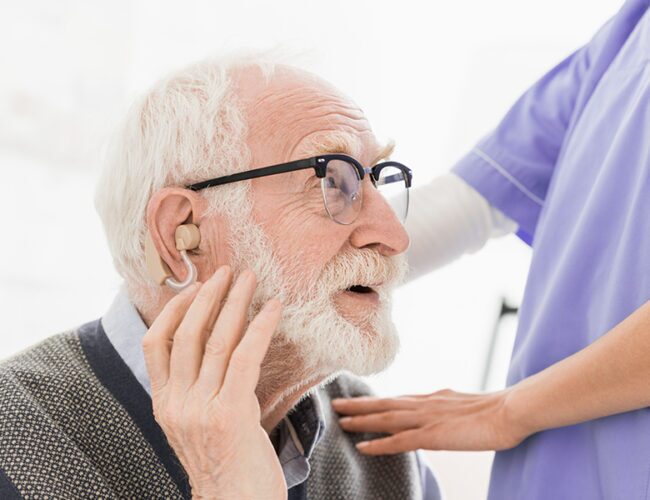 Senior man testing out a hearing aid