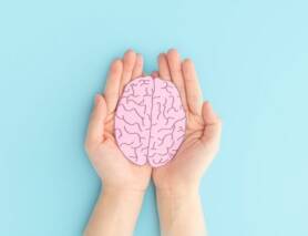 hands holding human brain shape made from paper