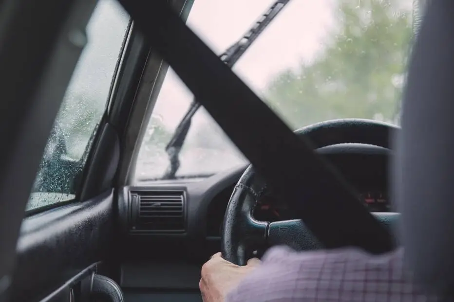 someone driving from the angle of the backseat looking out the windshield
