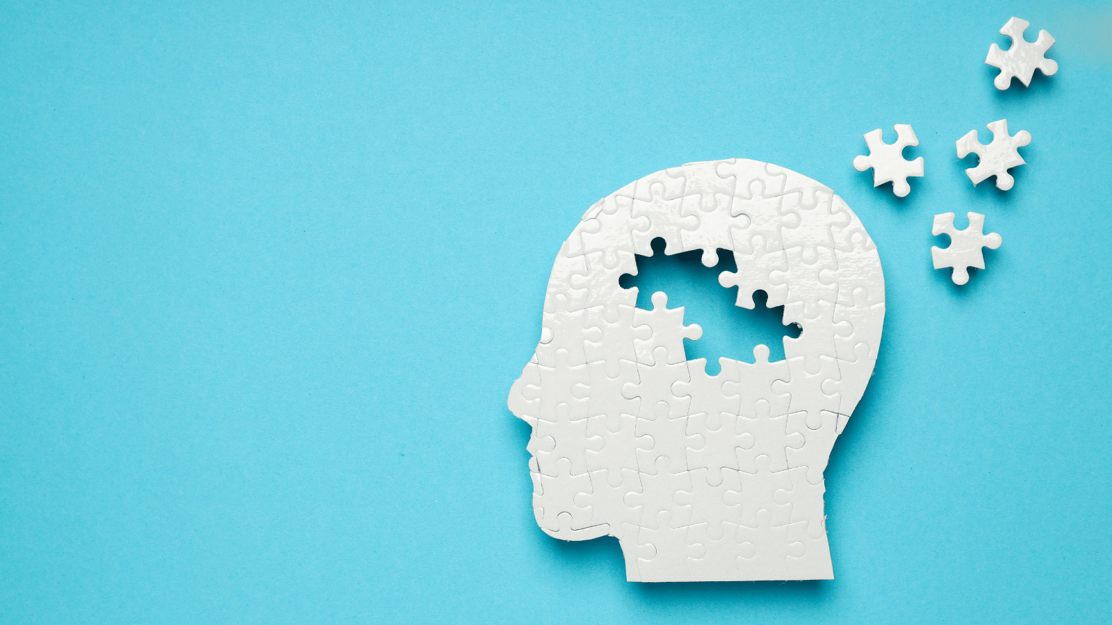 illustration of a white head silhouette as a puzzle with pieces from the brain area pulled out and scattered.