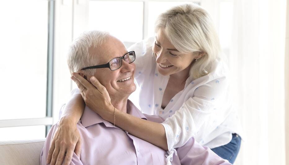 senior couple holding each other in an embrace indoors