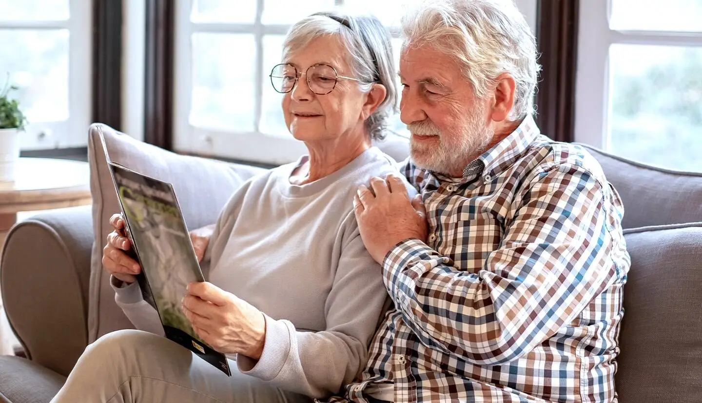 Elderly couple looking at Memory Care community brochure.