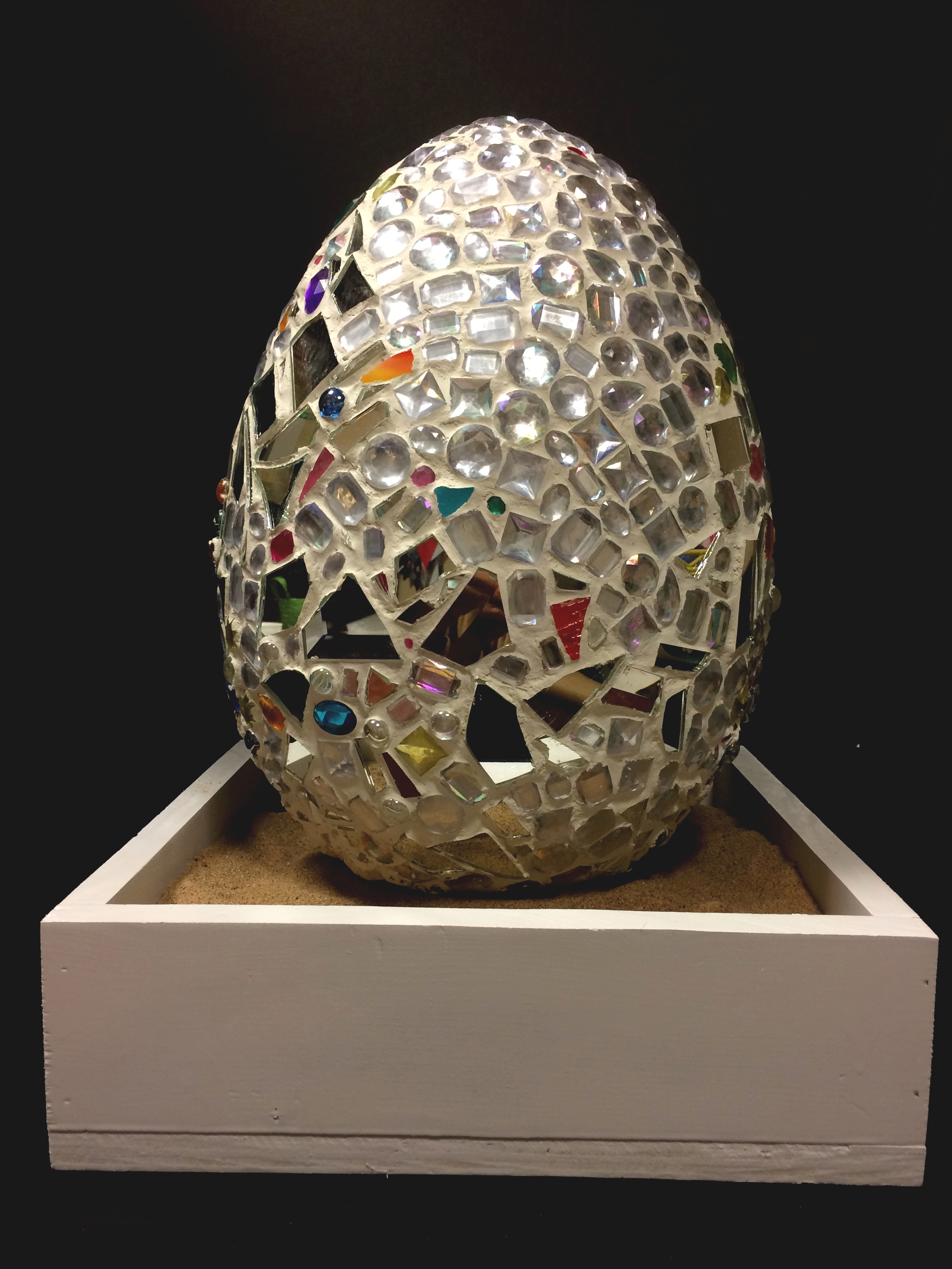 A large grey and colorful mosaic egg