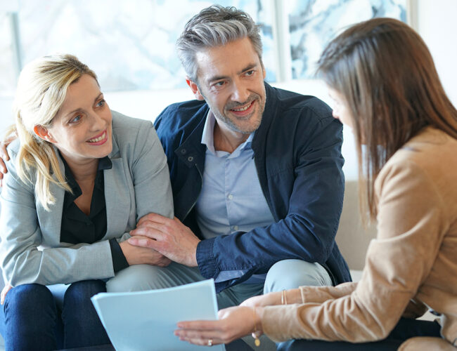 Two women having a conversation with a man in a suit
