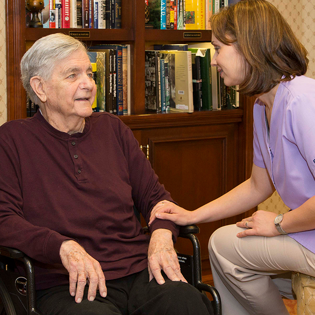 Two women having a conversation in a library