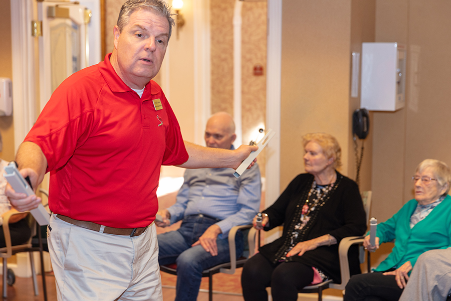 Musical Therapist in Red Polo leading residents in activity