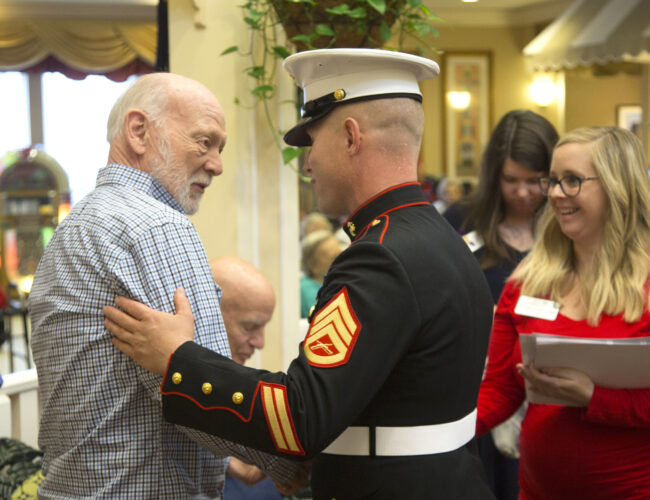 Staff Sergeant Joshua Jacobs shaking hands with a male resident