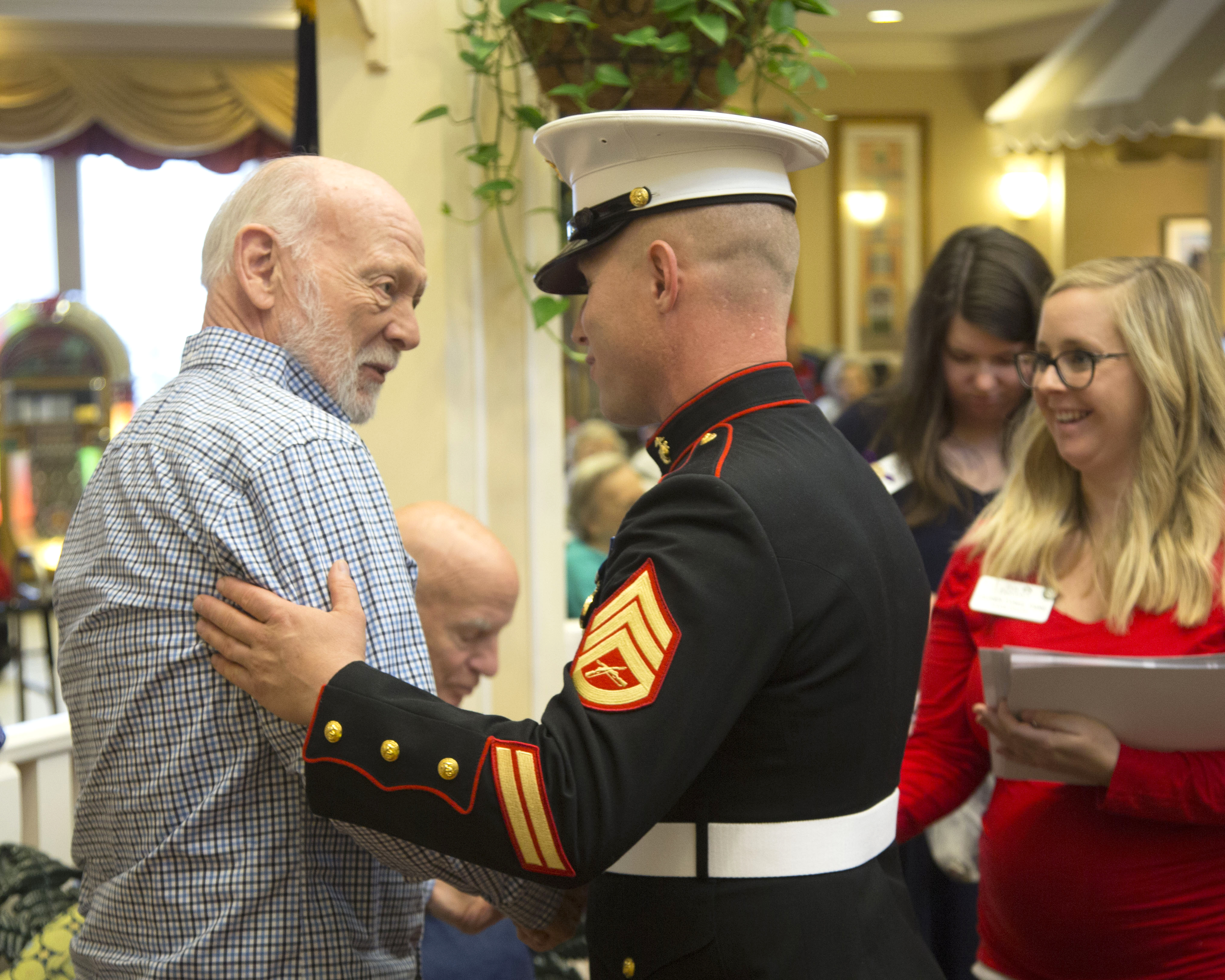 Staff Sergeant Joshua Jacobs shaking hands with a male resident