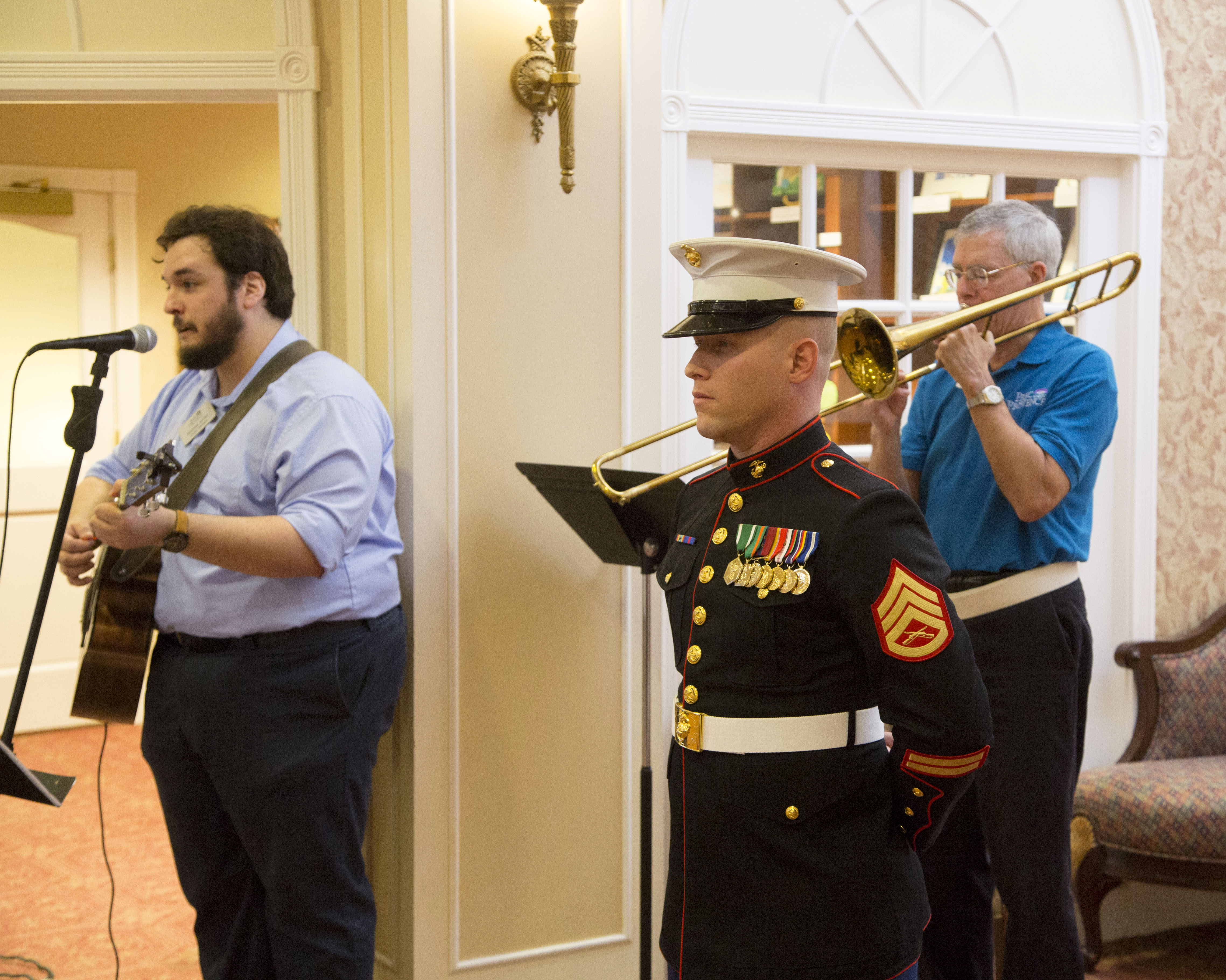 Two men playing instruments to God Bless America while a Staff Sergeant stands at attention