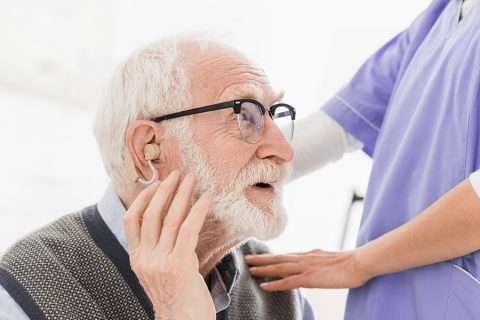 Senior man testing out a hearing aid