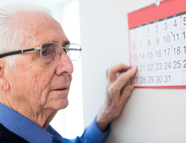 A man pointing to a day on a calendar.