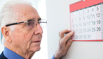 A man pointing to a day on a calendar.