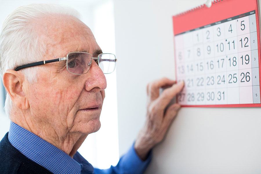 A man pointing to a day on a calendar.