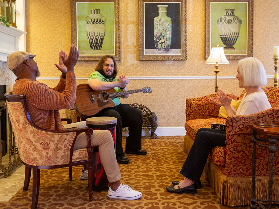 A caregiver playing the guitar for a residents.