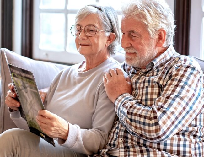 Elderly couple looking at Memory Care community brochure.