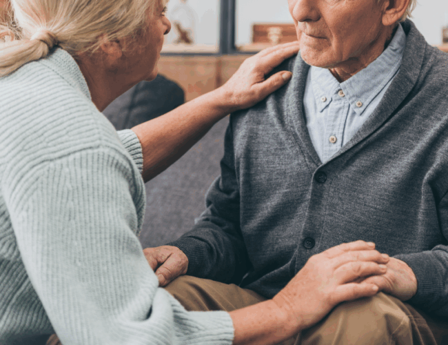 A woman comforts and older man.