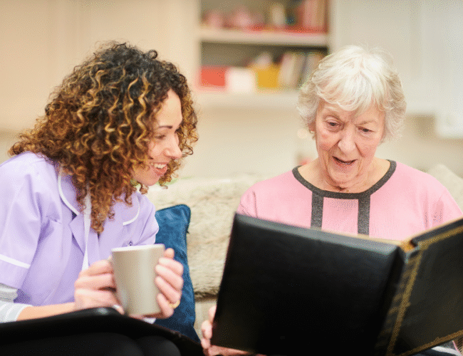 Senior woman reading a book with a nurse